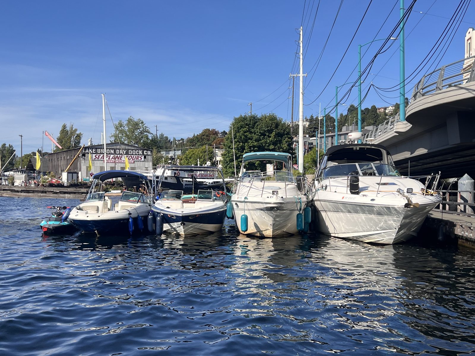 The Seattle Rent A Boat fleet lined up at the South Lake Union dock beside Seattle Seaplanes